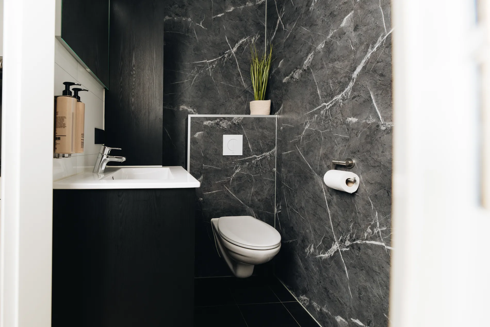 Stijlvolle badkamerinrichting bij Resort Land & Zee met marmerlook wanden en moderne sanitaire voorzieningen.